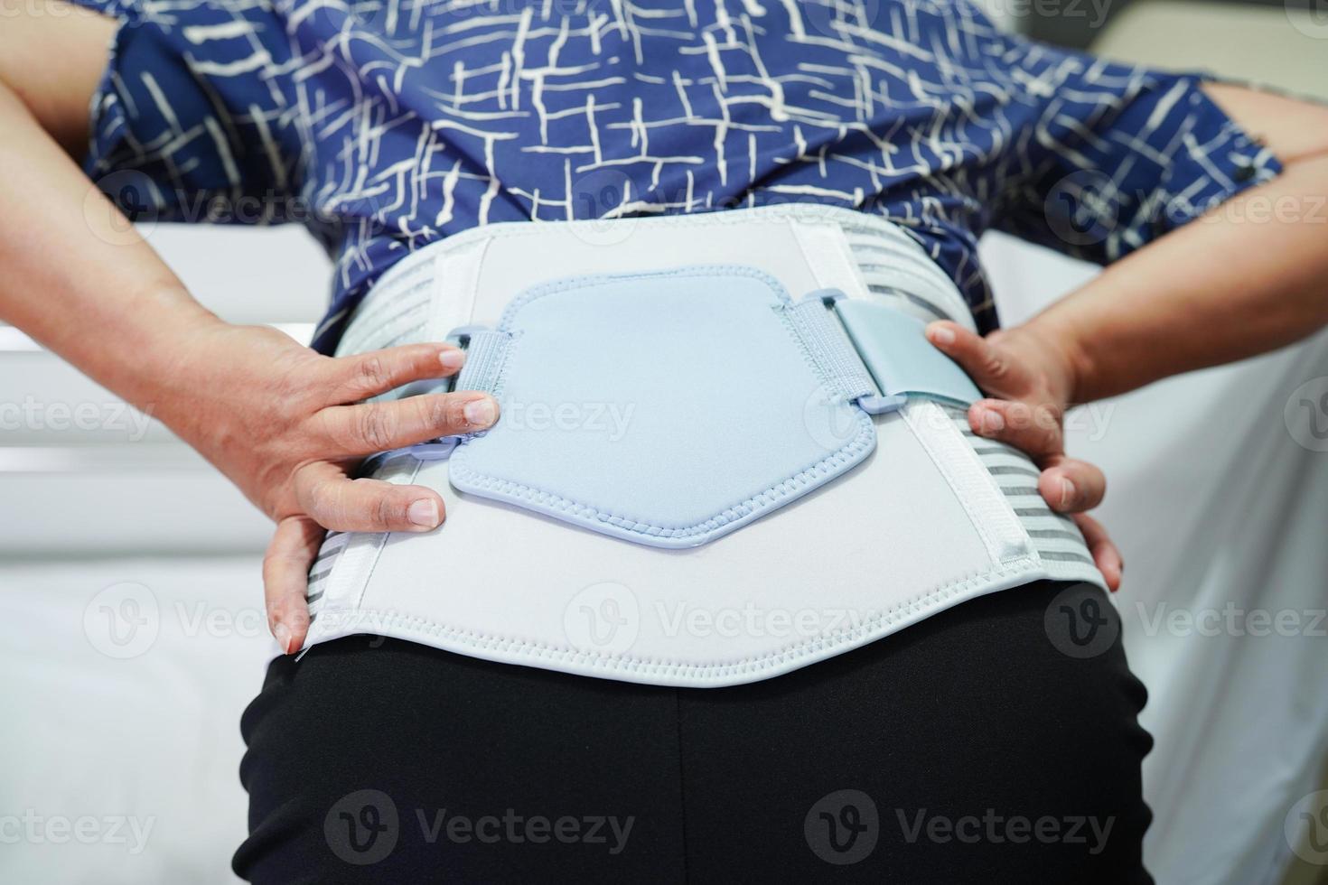 Asian senior wearing elastic support belt can help reduce back pain