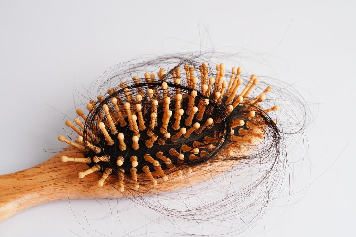 Caída de pérdida de cabello con cepillo de peine aislado sobre fondo blanco. foto