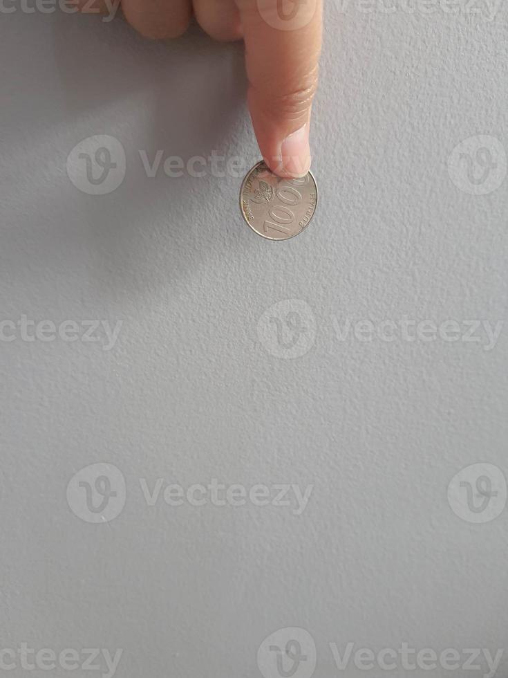 Isolated photo of a hand holding a thousand rupiah coin.