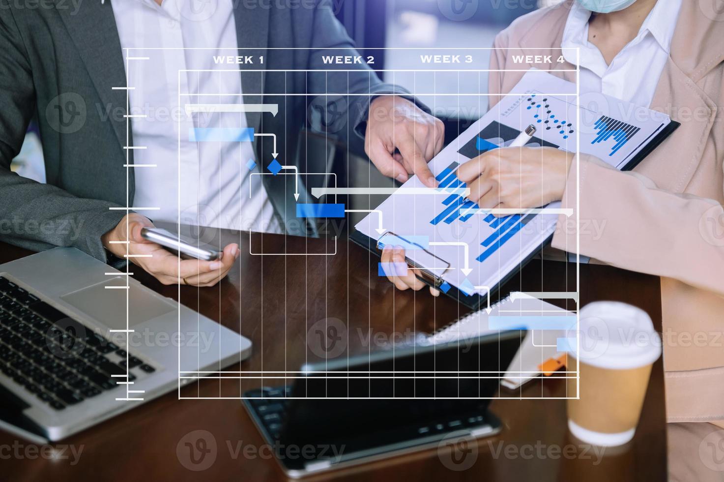 Project manager working and update tasks with milestones progress planning and Gantt chart scheduling diagram. business working with smart phone, tablet and laptop in office. photo