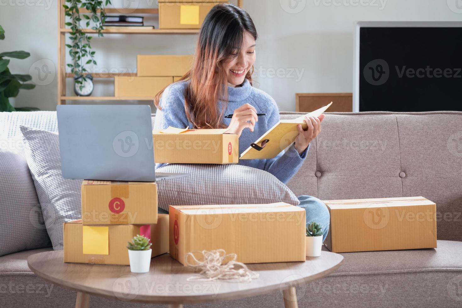 Young Asian SME businessman starting a small and boxed SME business as an online business. Online SME business concept. photo