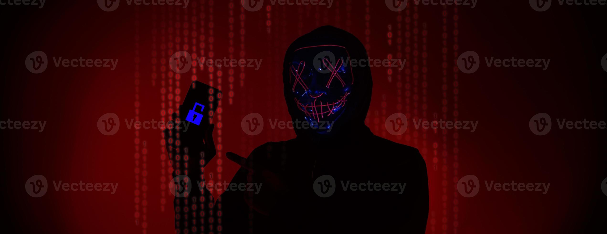 Digital security Concept. Anonymous hacker with mask holding smartphone hacked. photo