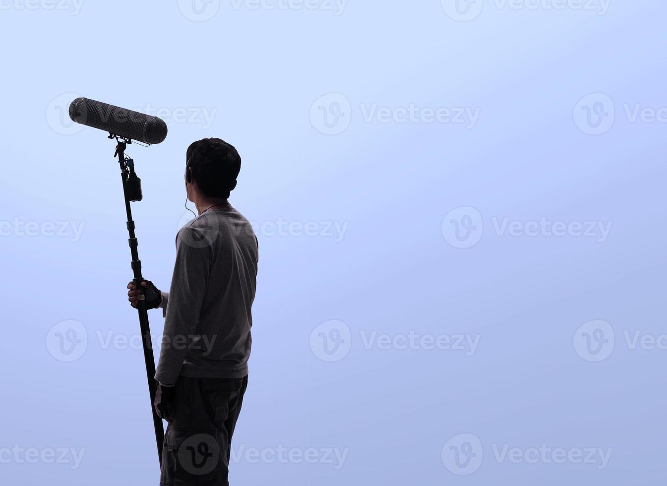 Sound boom operator recording sound by microphone fisher for movie set in a studio. photo