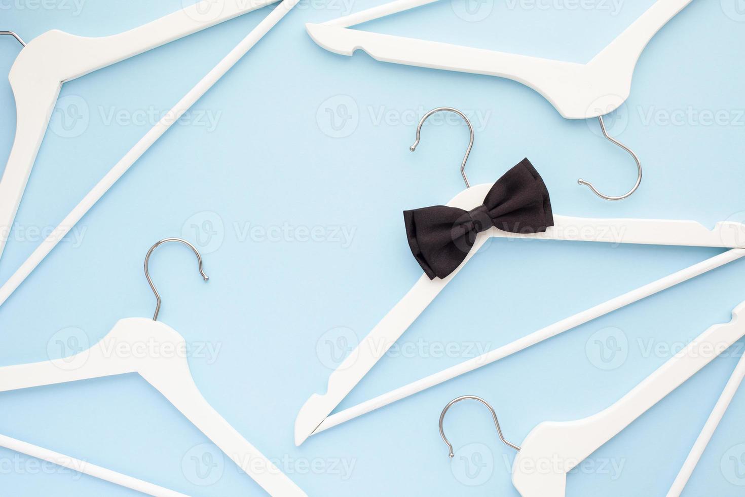 White wooden hangers on blue background photo