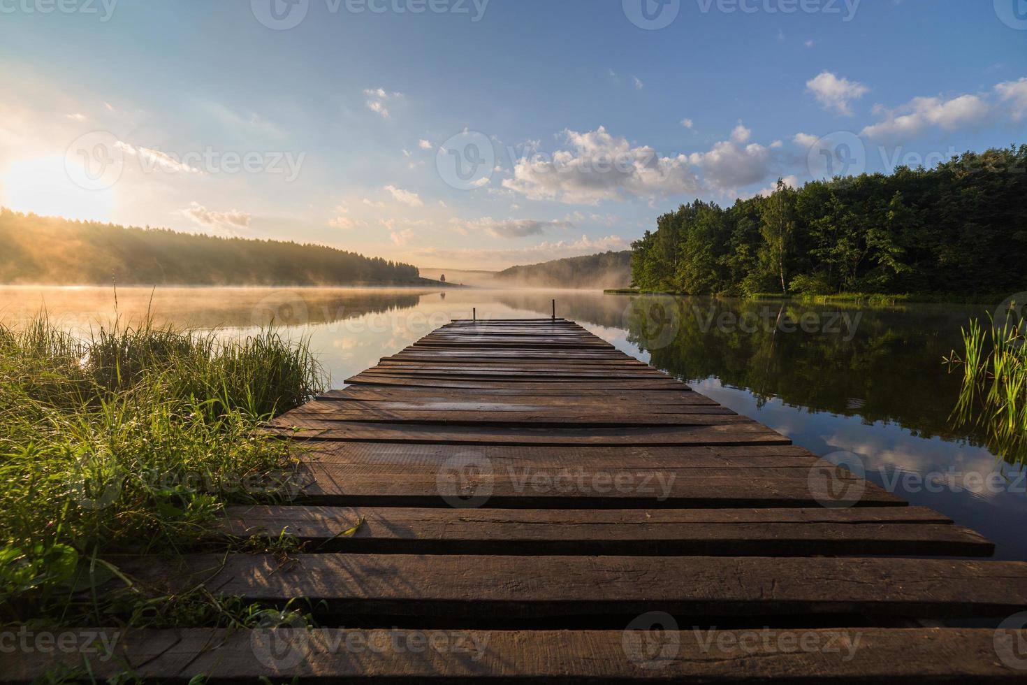 sunrise over the foggy river with a wooden pier photo