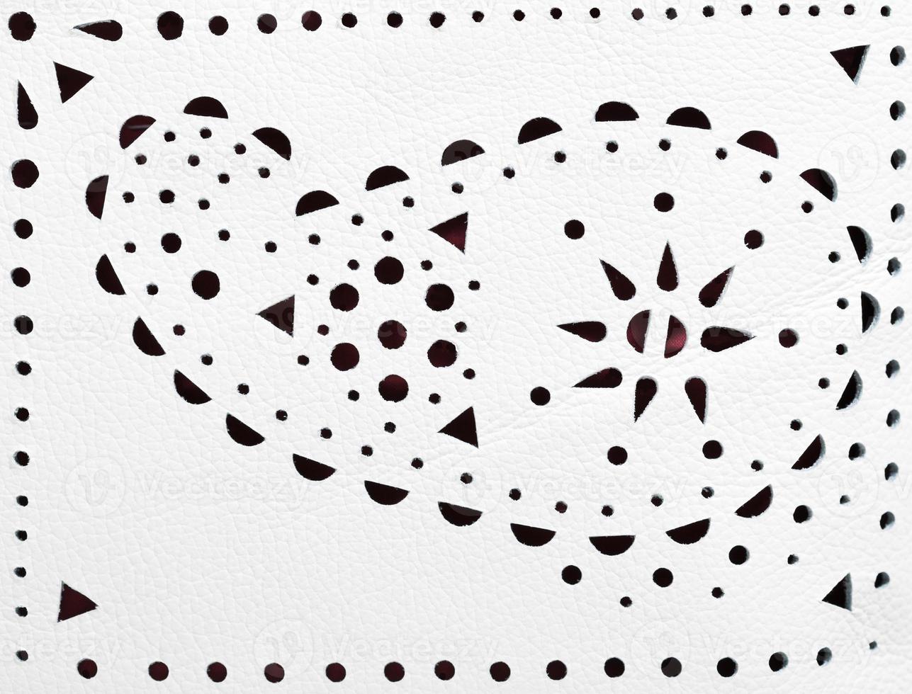 perforated paisley ornament on white leather photo