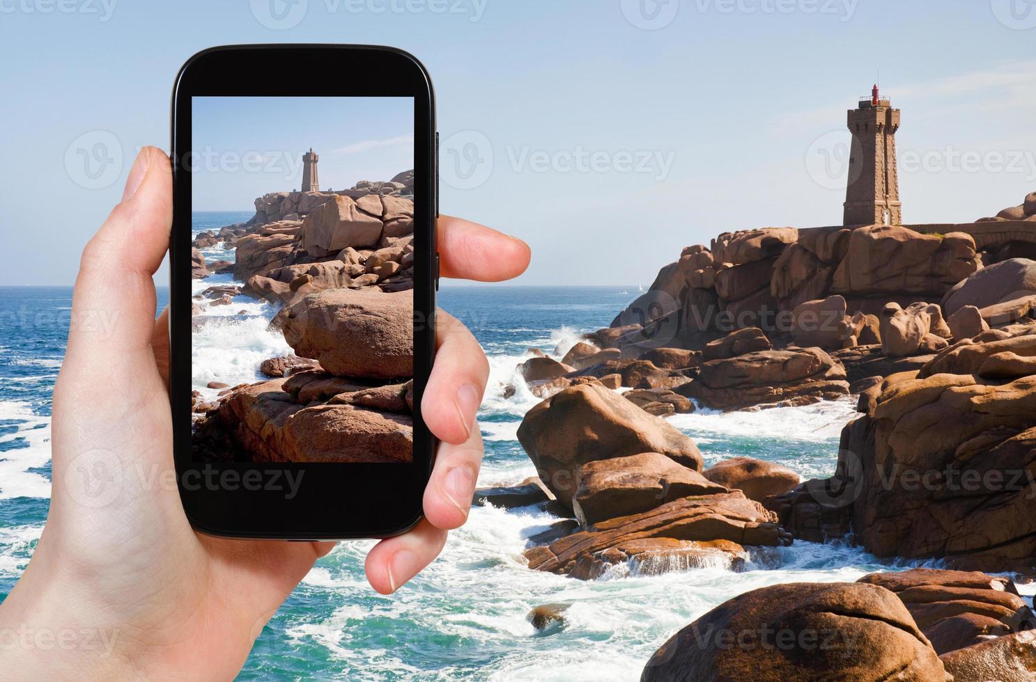 tourist taking photo of Lighthouse in Brittany