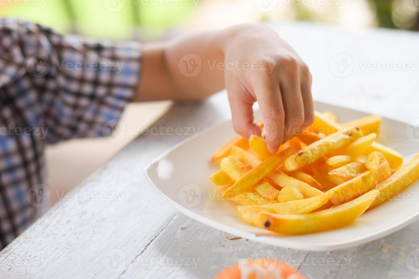 child eating french fries or potato chips. photo