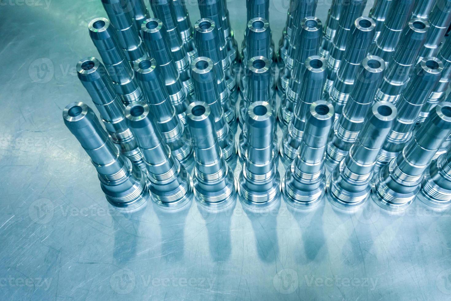 Shiny blue steel parts background, long clean steel rods after fine cnc turning. photo