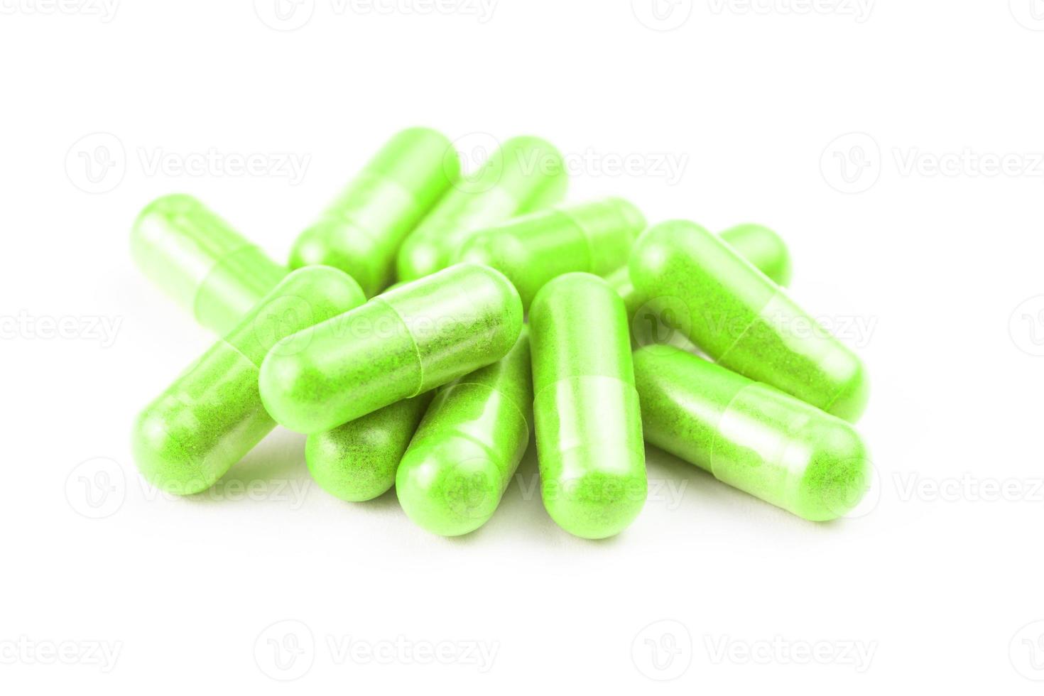 pile of ufo green organic capsules isolated on white background closeup with selective focus photo