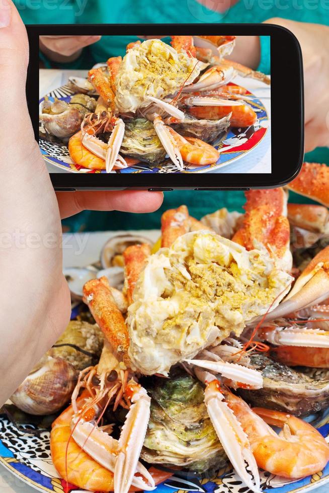 tourist photographs of plate with crab and seafood photo