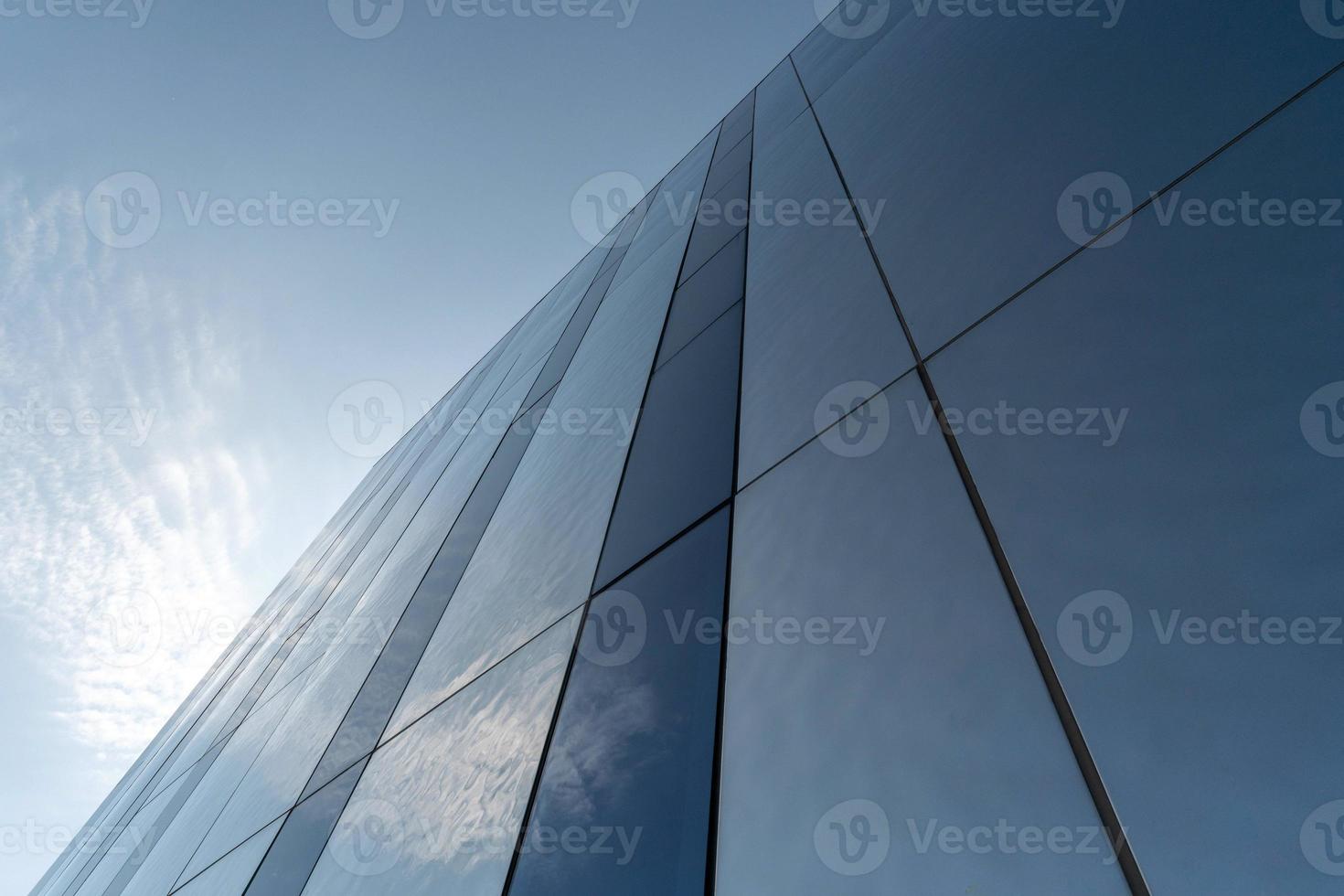 Modern mirror wall decoration of business center, copy space. Bottom view to texture of exterior design. Contemporary pattern of buildings. Looking up. photo