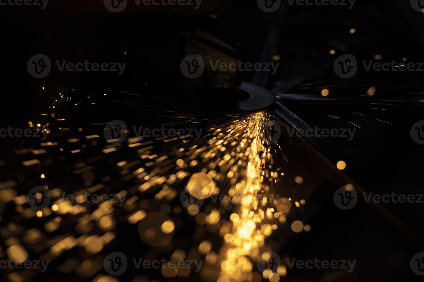 Sparks of yellow color. Metal treatment. Lights in dark. Sparks from split grinding disc. photo