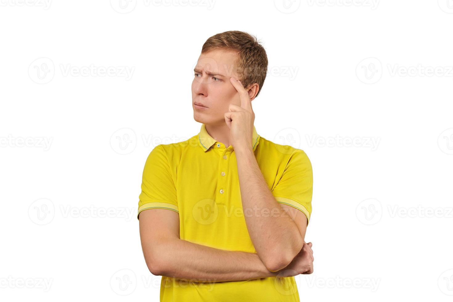 Thoughtful guy in yellow T-shirt looking to left, white background, philosophical reflection photo