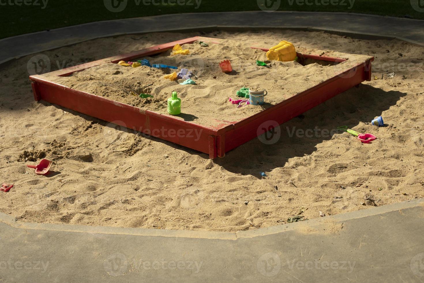 Children's playground with sand. Children's sandbox on street. Place for game kids. Sand with toys. photo