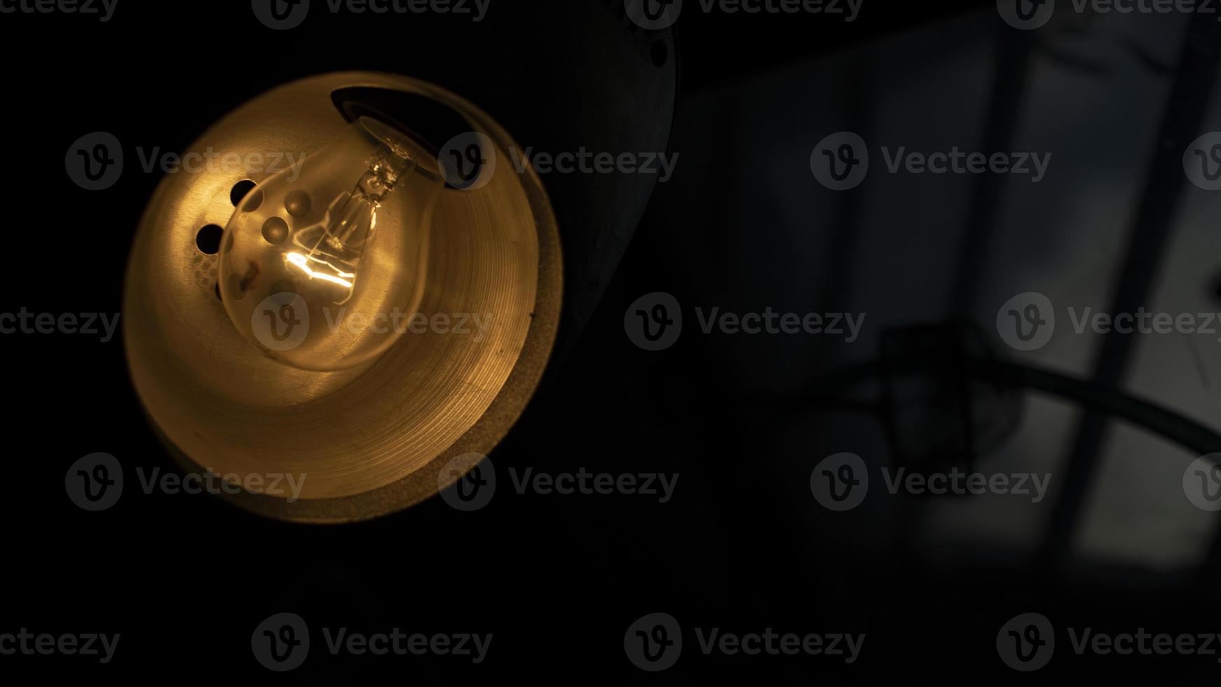 Table lamp in dark. Incandescent lamp in interior. photo