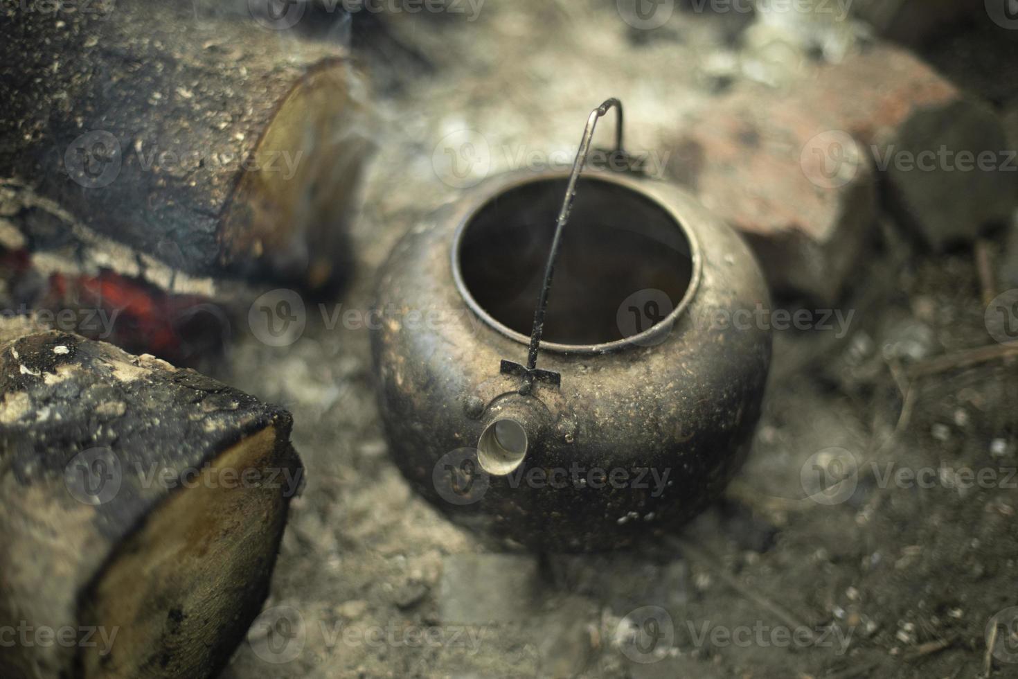 Kettle on picnic. Campfire on campsite. Burning firewood. Flames of fire. photo