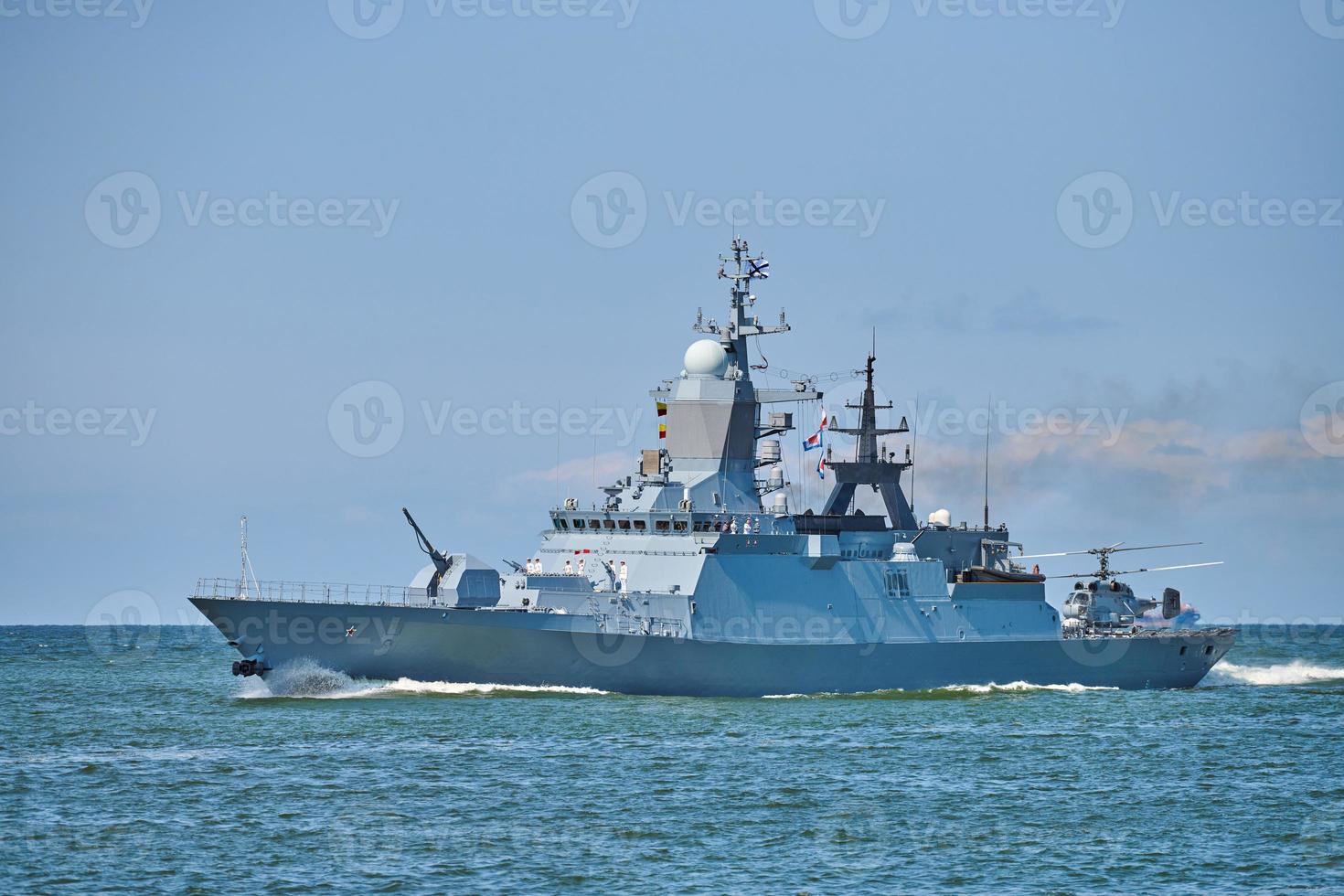 Battleship war ship boat corvette with helicopter on deck in beautiful blue sea. Navy warship photo