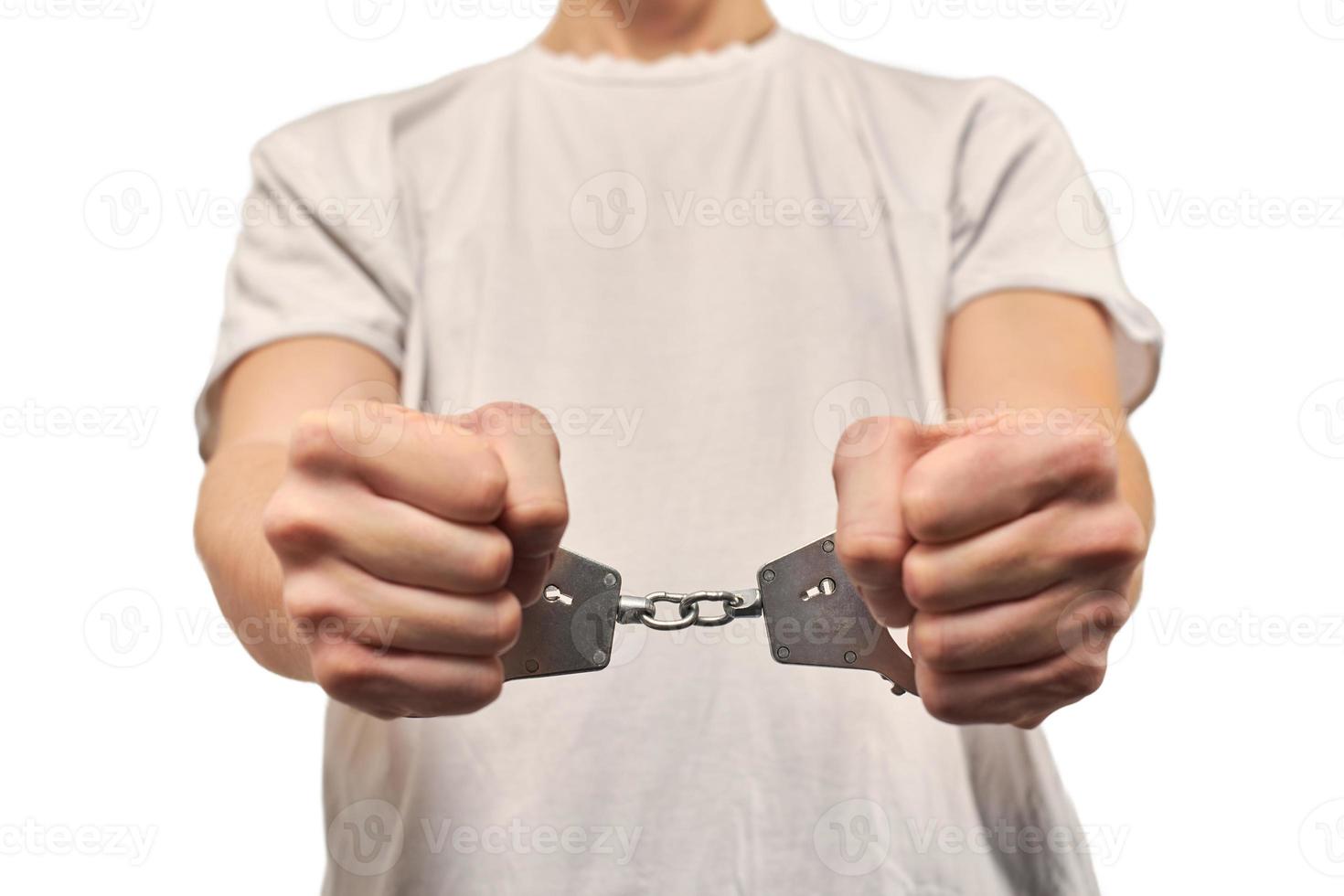 Hands of criminal in handcuffs, arrest of dangerous criminal, violation of law, white background photo