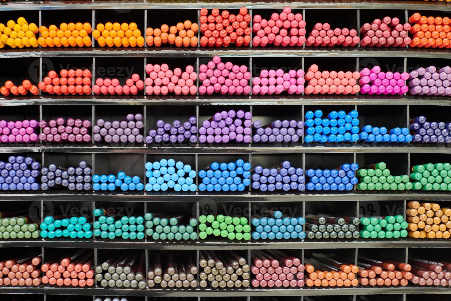 Colored pens, pencils, markers on shelf in stationery shop photo