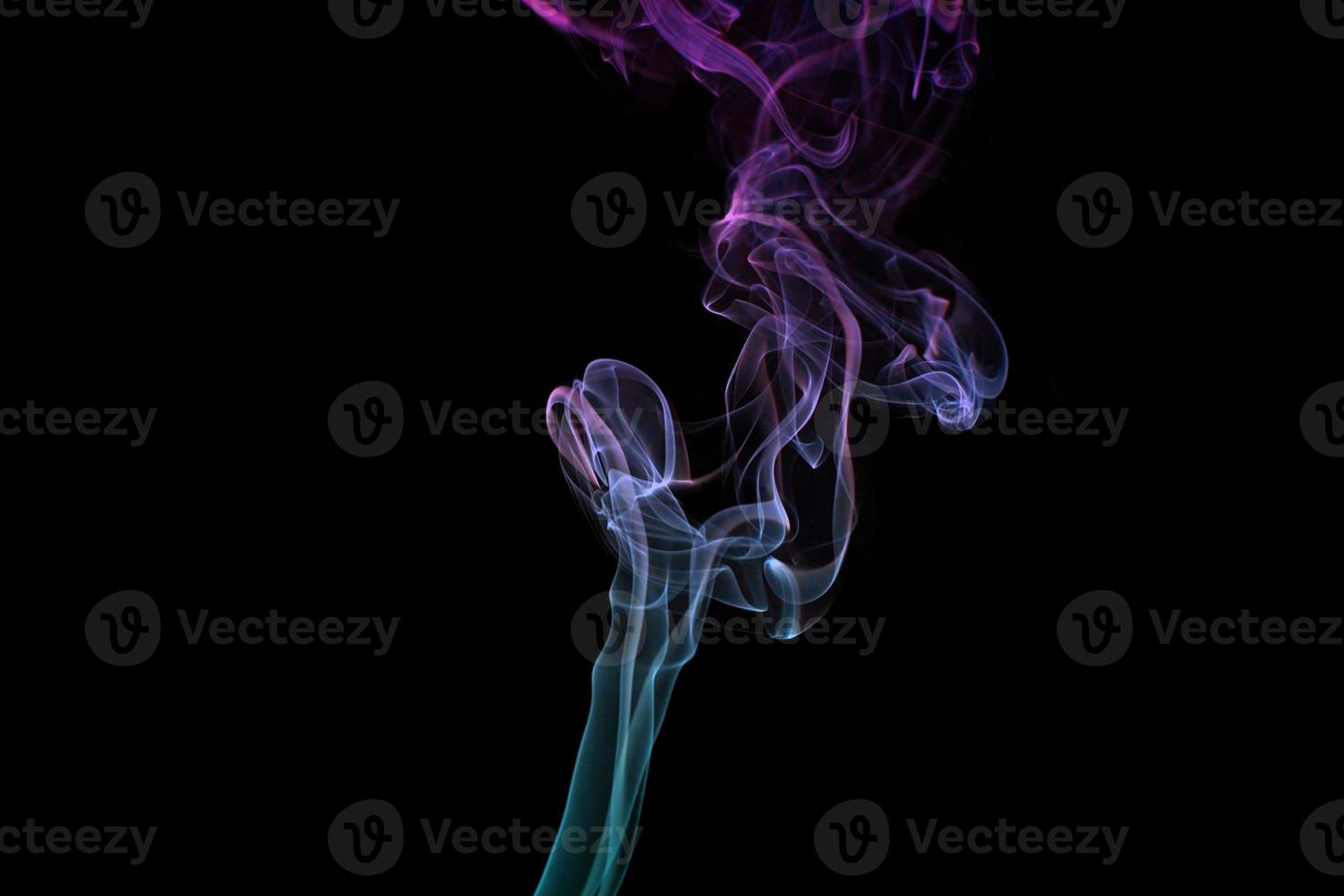 Multicolored smoke for aromatherapy relaxation on black background, beautiful swirled puffs of smoke photo