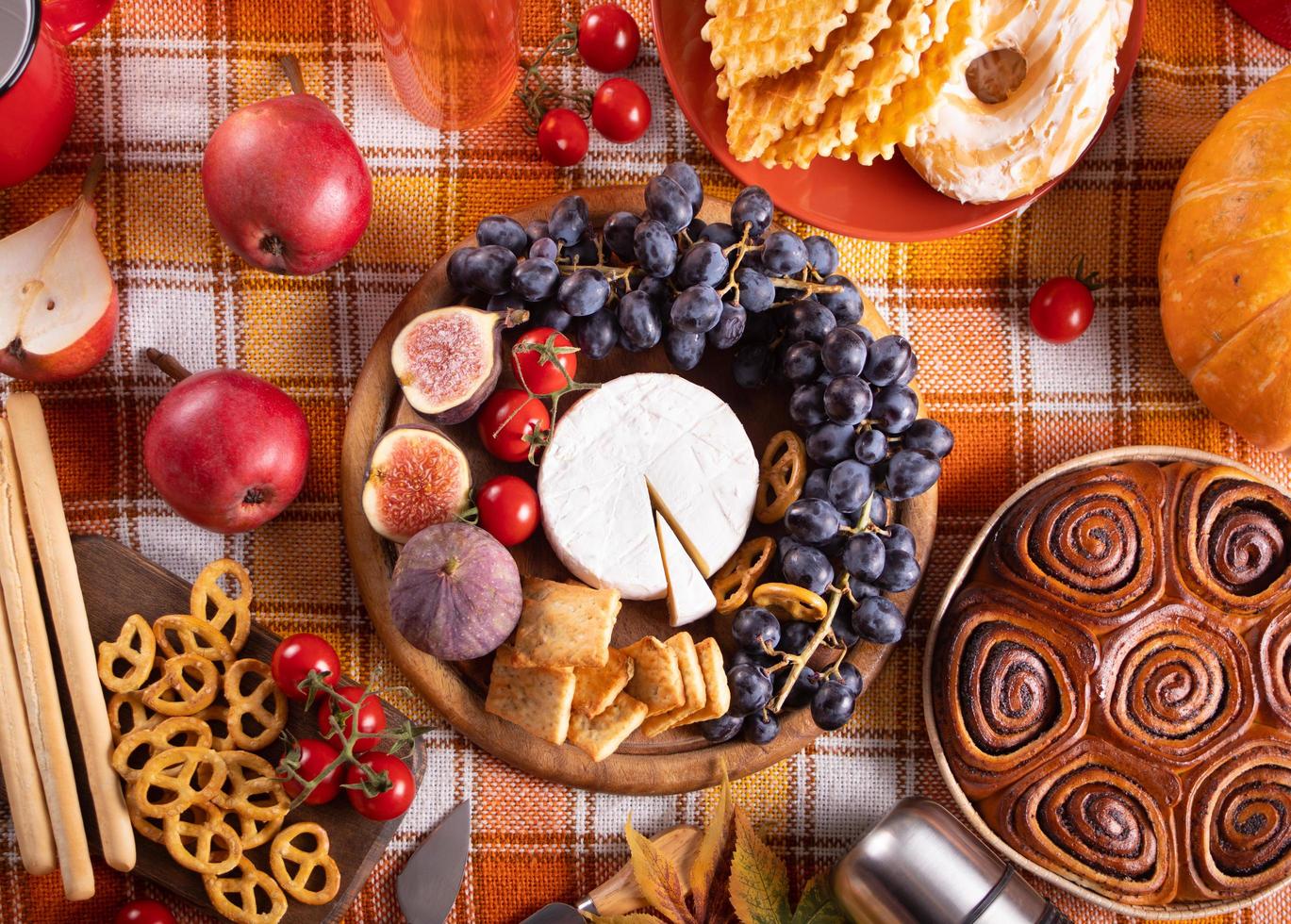 Autumn outdoor picnic set or dinner for celebration Thanksgiving Day. Holiday party. Festive table. Snacks, friuts,pie, vegetables, wine glasses. photo