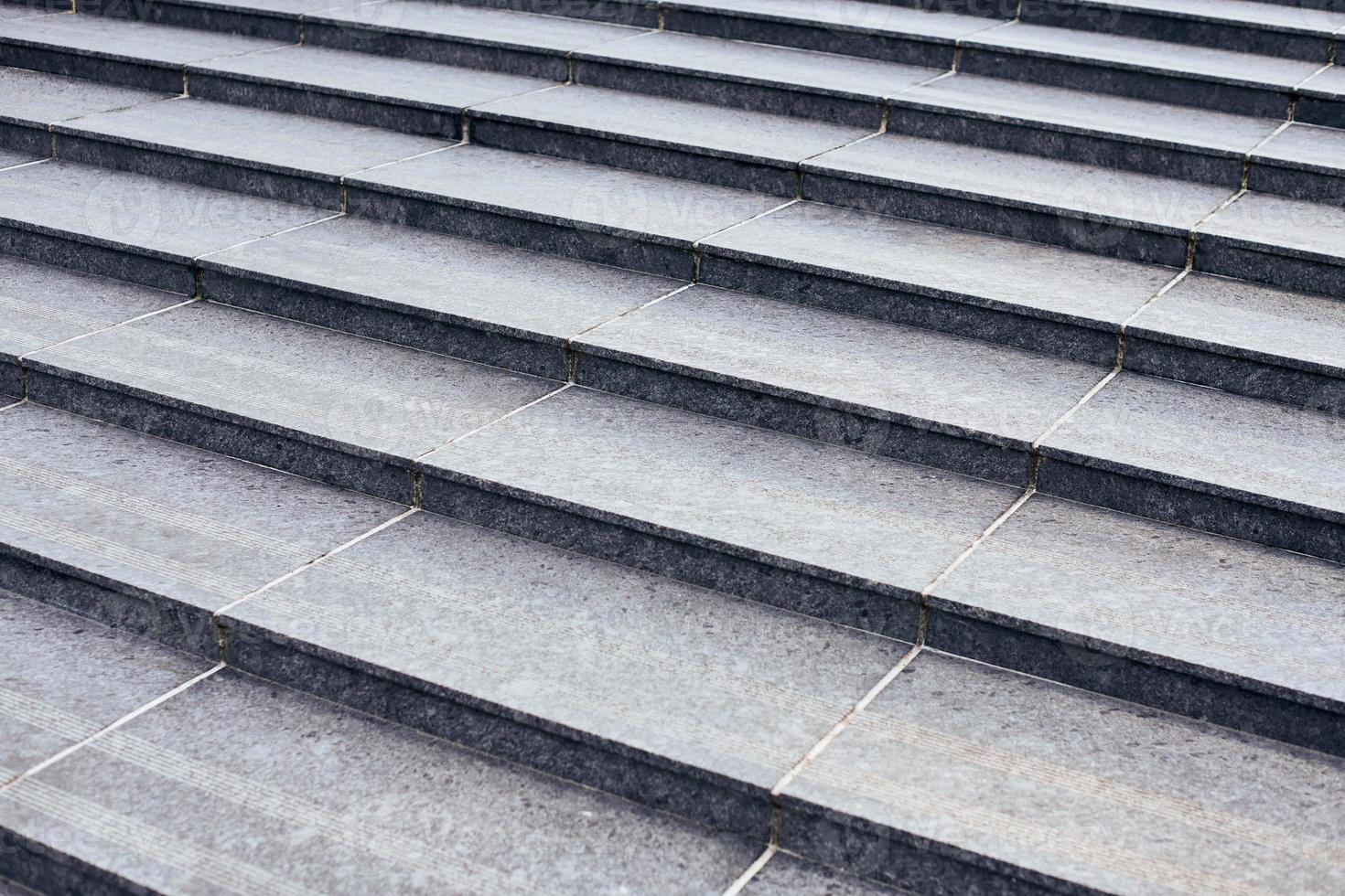 Grey stone steps in modern style, large staircase with stone-like grey texture, wide granite ladder photo
