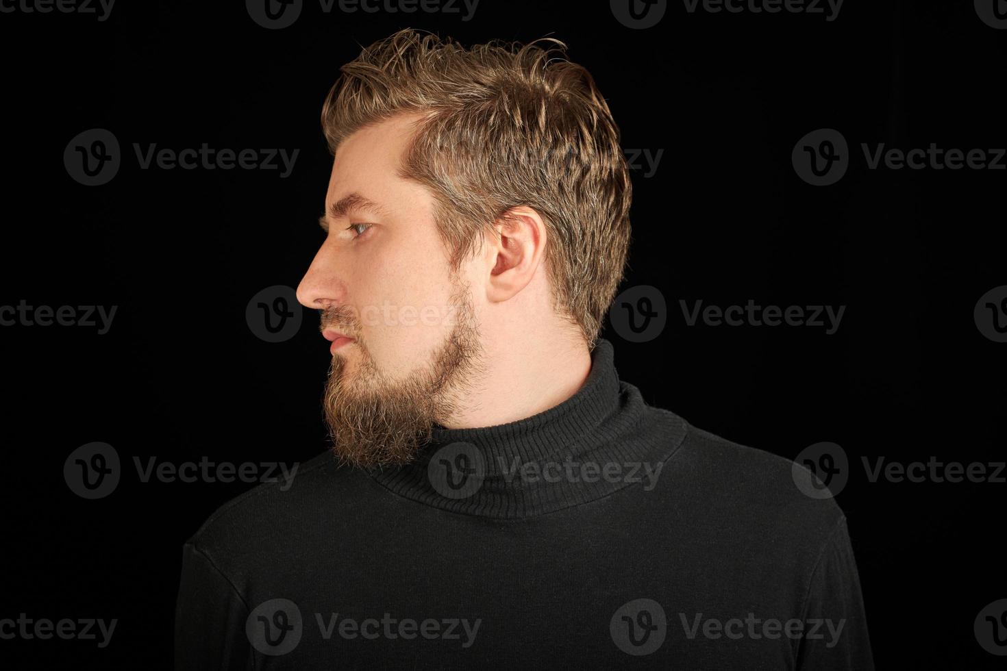 Cute bearded man, half-face portrait, black background photo