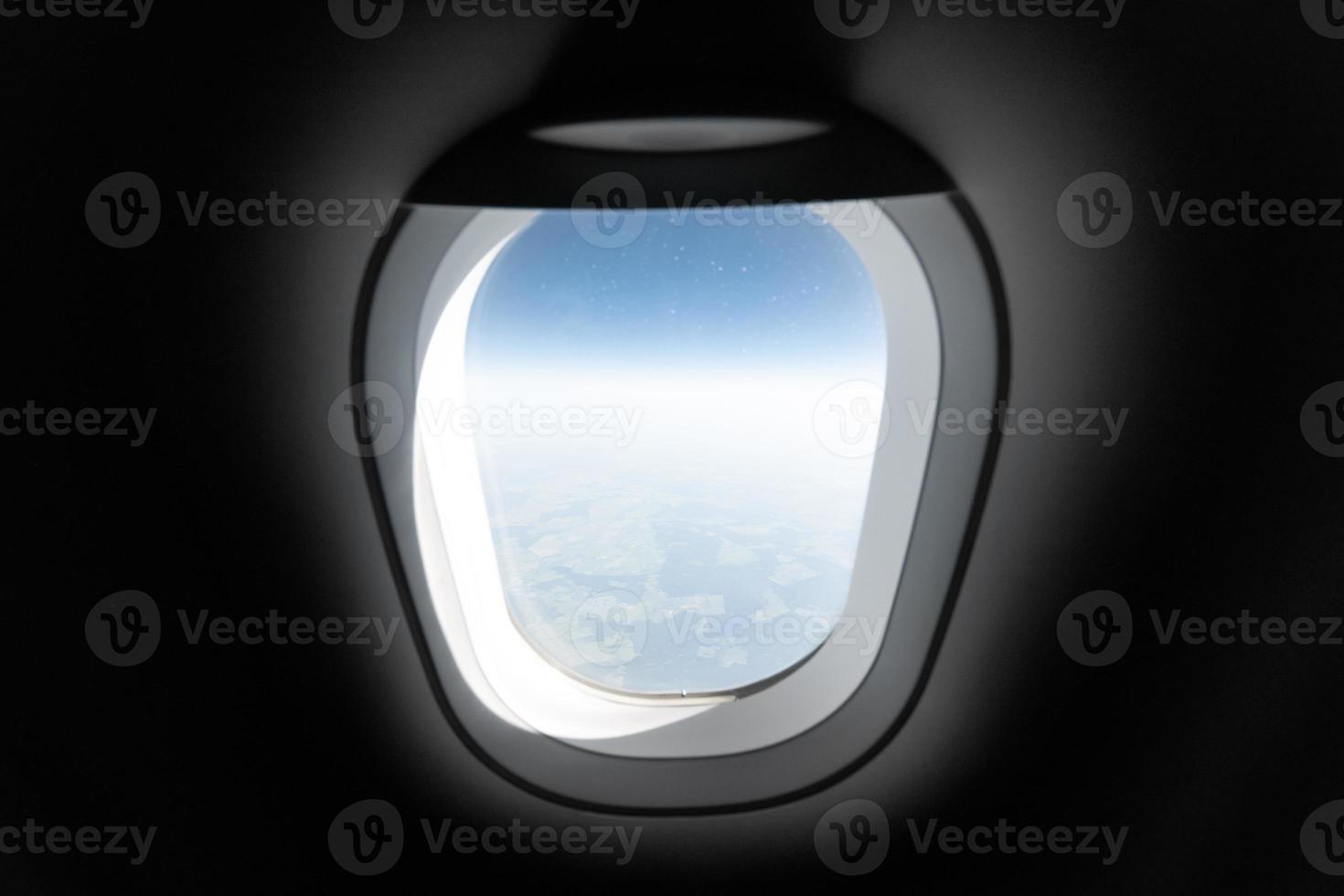 Airplane window view to cloudy sky and earth. Beautiful landscape from aircraft cabin. Flying without fear of flying, incidents and turbulence. photo