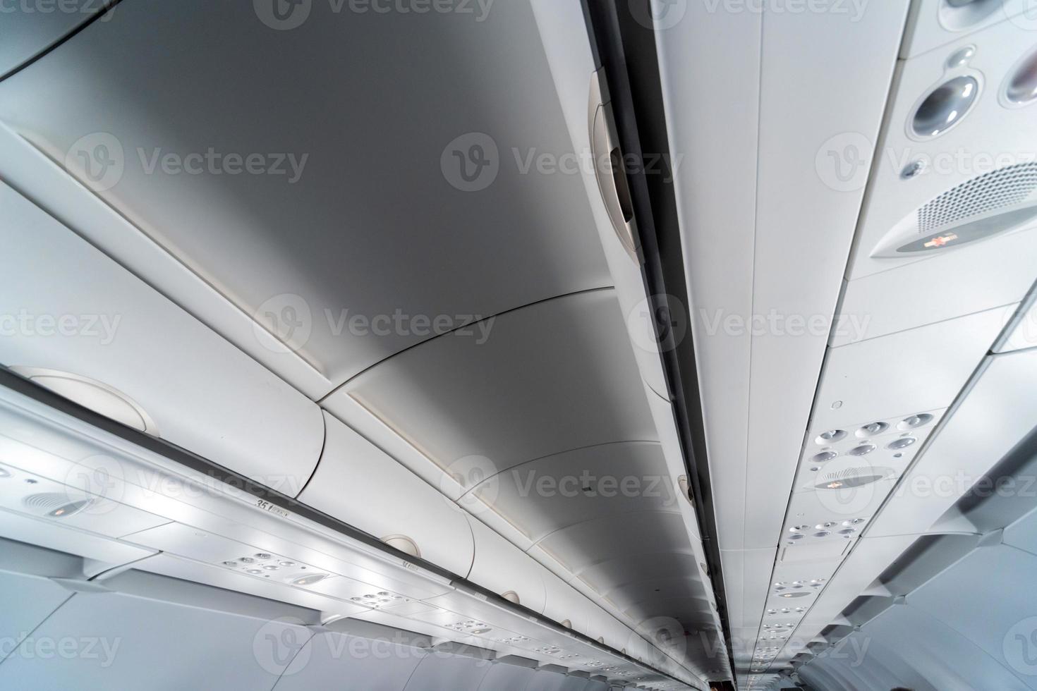 Airplane air conditioning control panel over seats. Stuffy air in aircraft cabin with people. New low-cost airline. photo