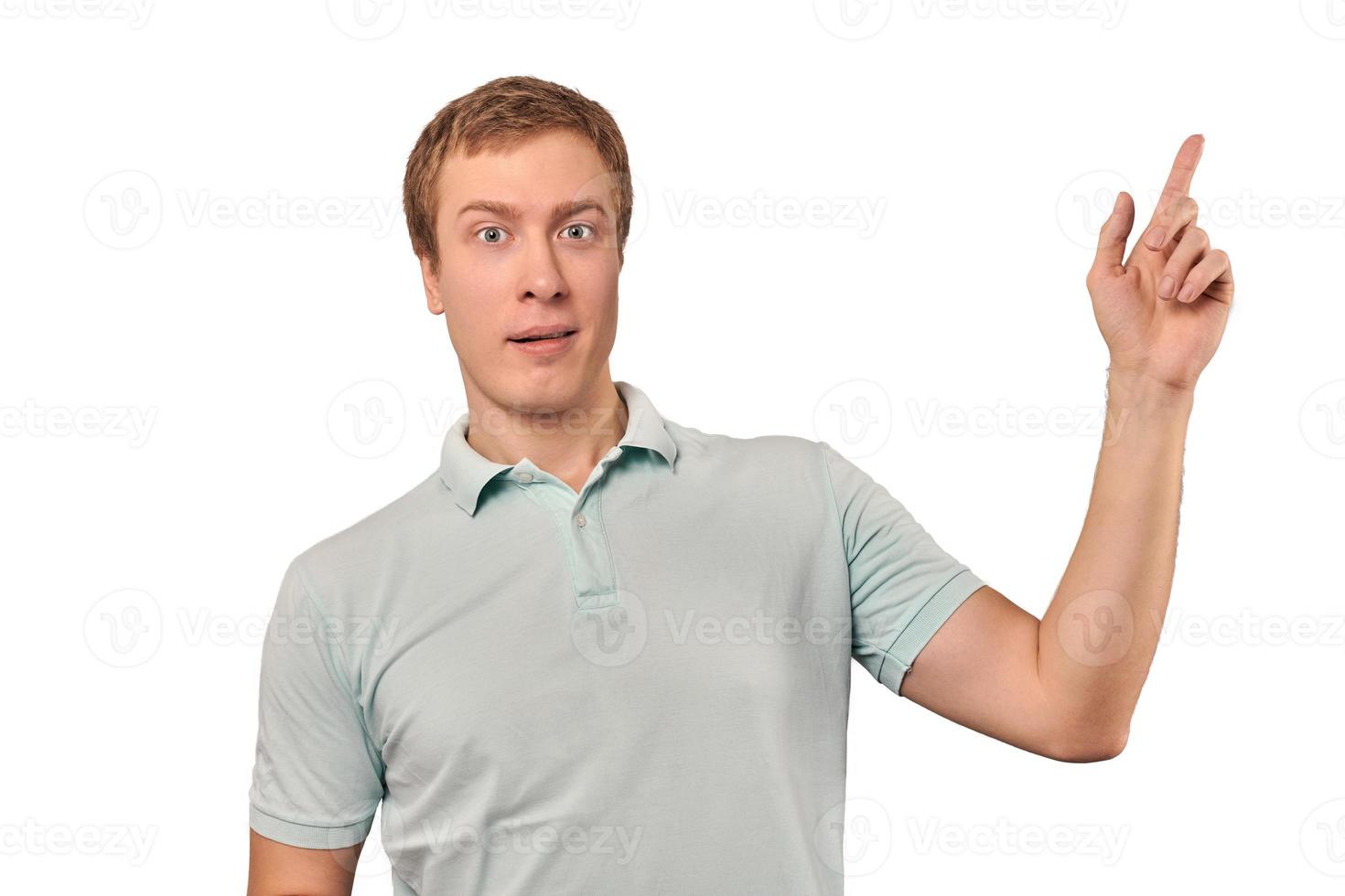 hombre sorprendido con expresión facial divertida en camiseta de polo de menta apuntando con el dedo a la derecha, aislado foto