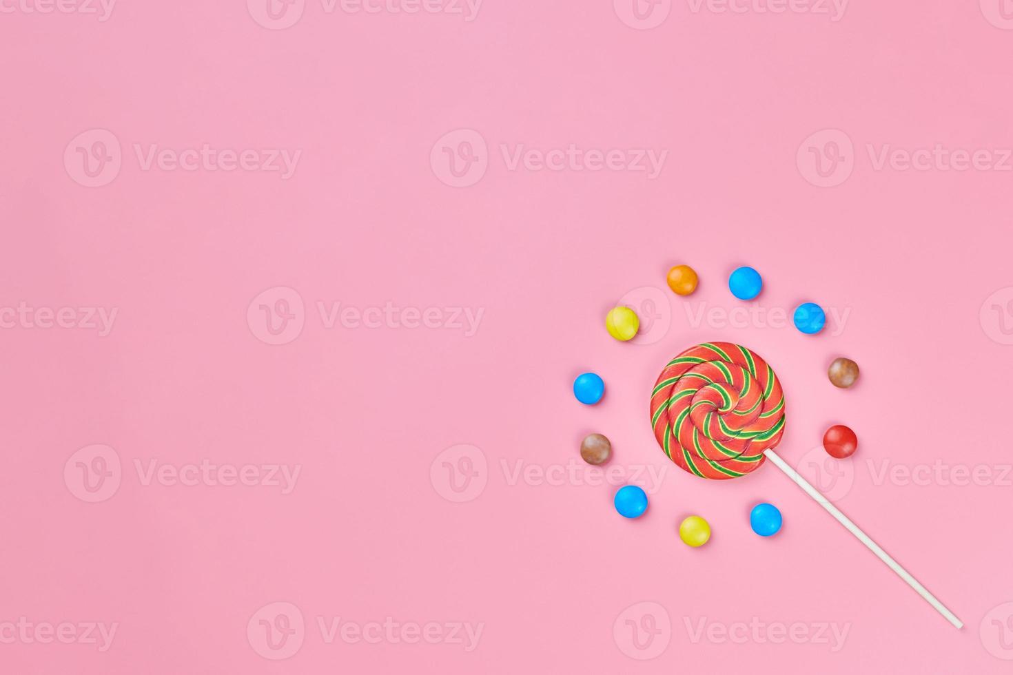 Sweet lollipop and candy on pink background photo