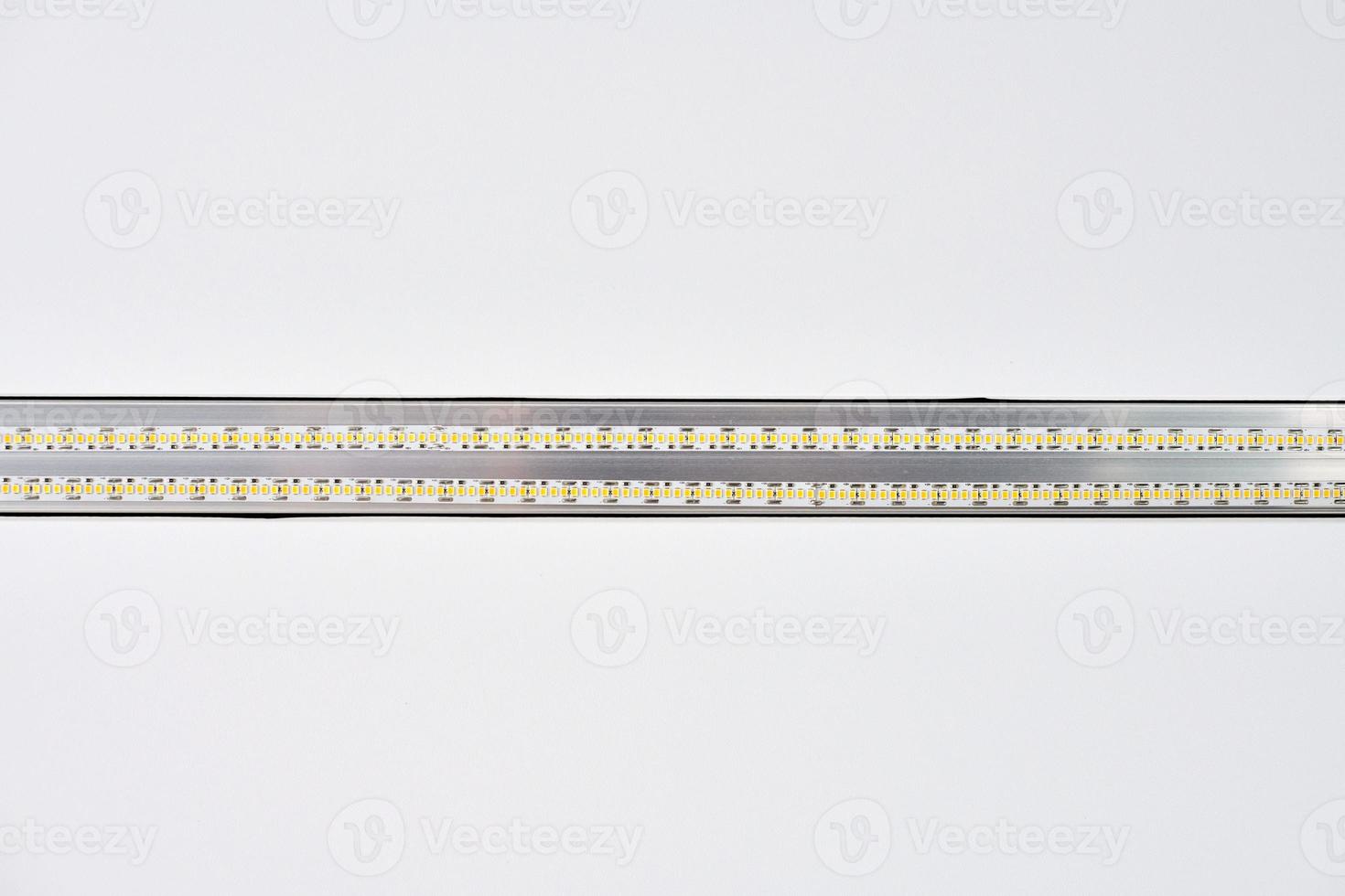 Strip LED light with aluminum profile on white stretch ceiling, modern construction, close up photo