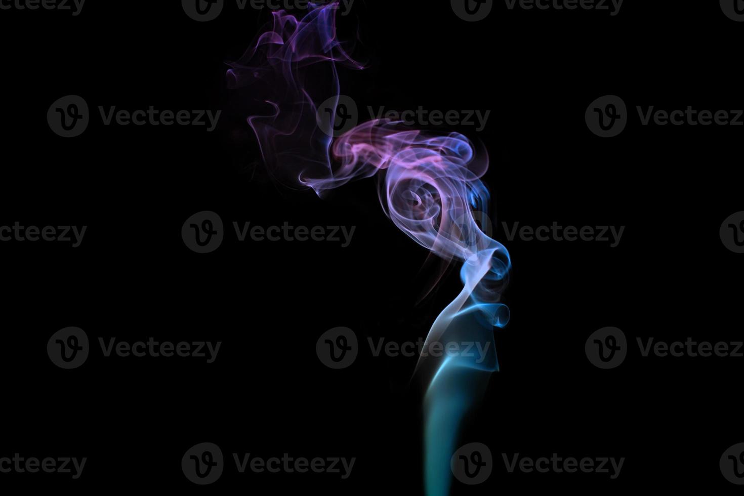 Multicolored smoke for aromatherapy relaxation on black background, beautiful swirled puffs of smoke photo