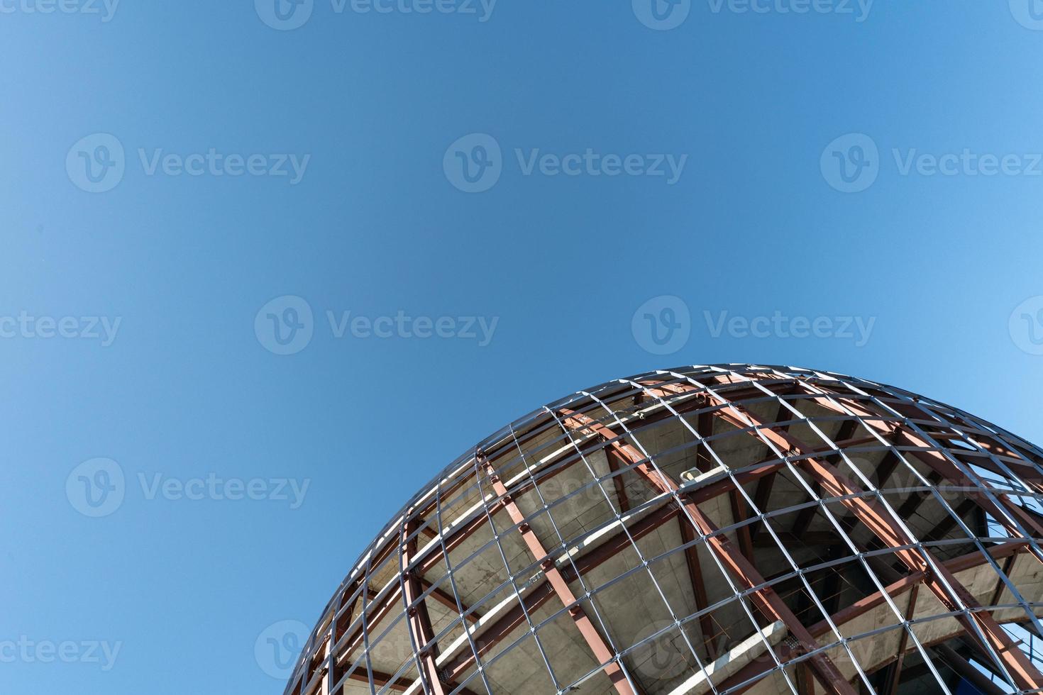 Unfinished sphere shape building, copy space. Construction of futuristic shopping mall or museum. Building constructed of concrete and reinforcement. photo