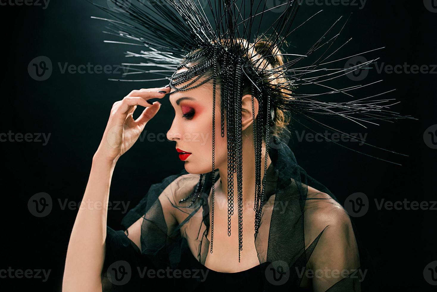 portrait of young beautiful woman like witch with red lips and black crown on dark background. Black dark beauty, Halloween concept photo