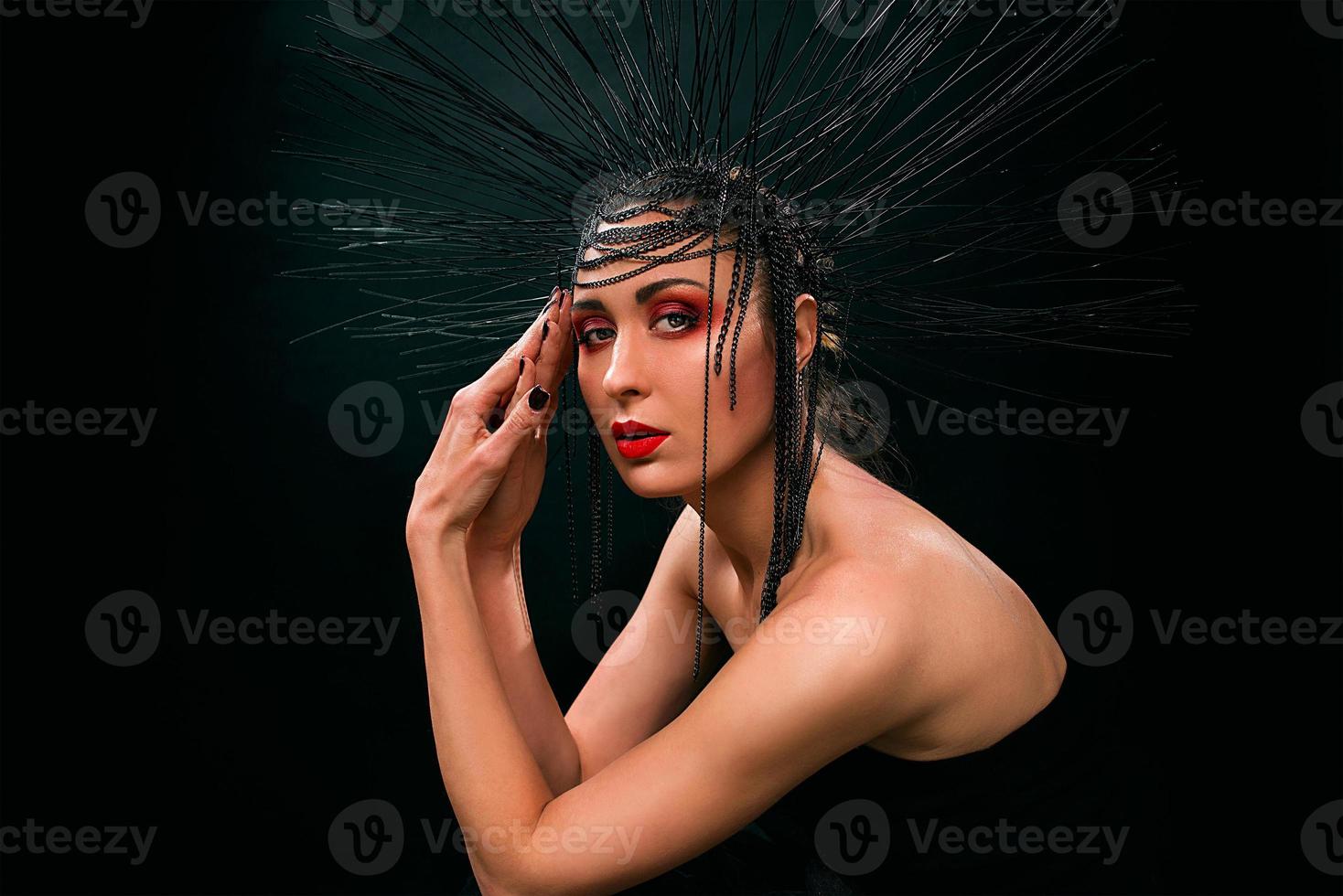 portrait of young beautiful woman like witch with red lips and black crown on dark background. Black dark beauty, Halloween concept photo