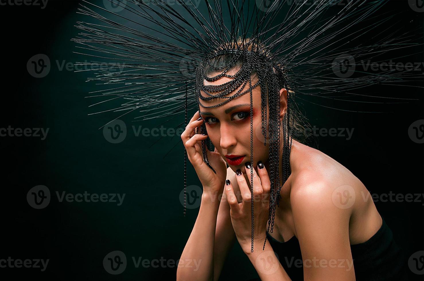 retrato de joven hermosa mujer como bruja con labios rojos y corona negra sobre fondo oscuro. belleza oscura negra, concepto de halloween foto