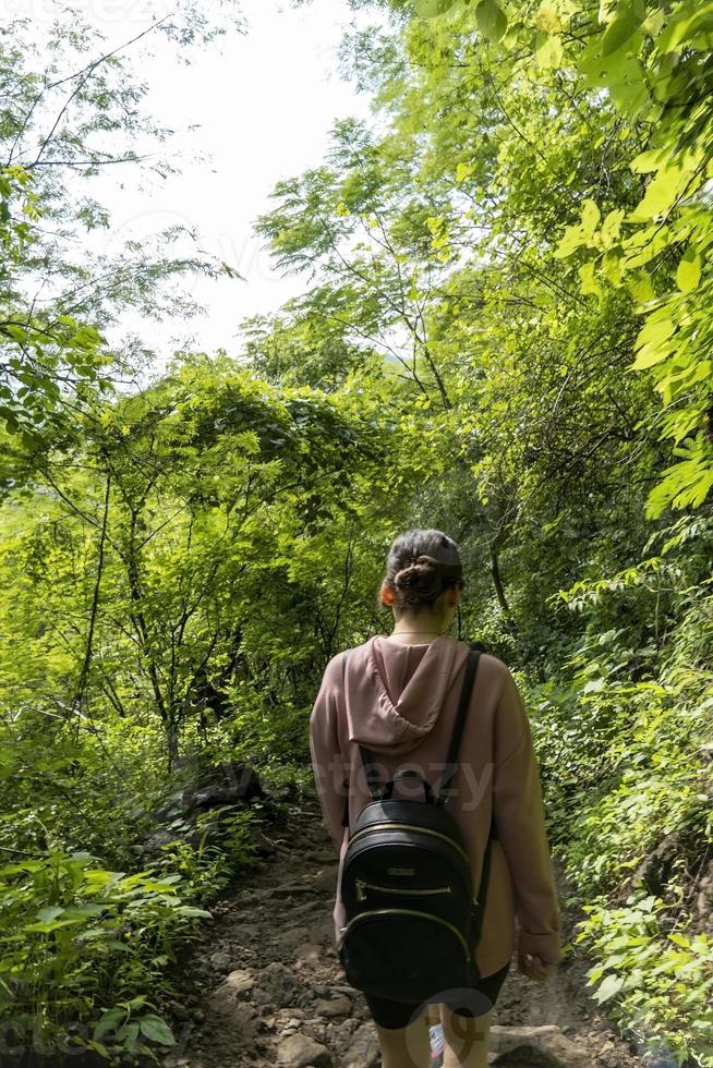 mujer joven descendiendo en el barranco, vegetación y árboles, barranco huentitan guadalajara, méxico foto