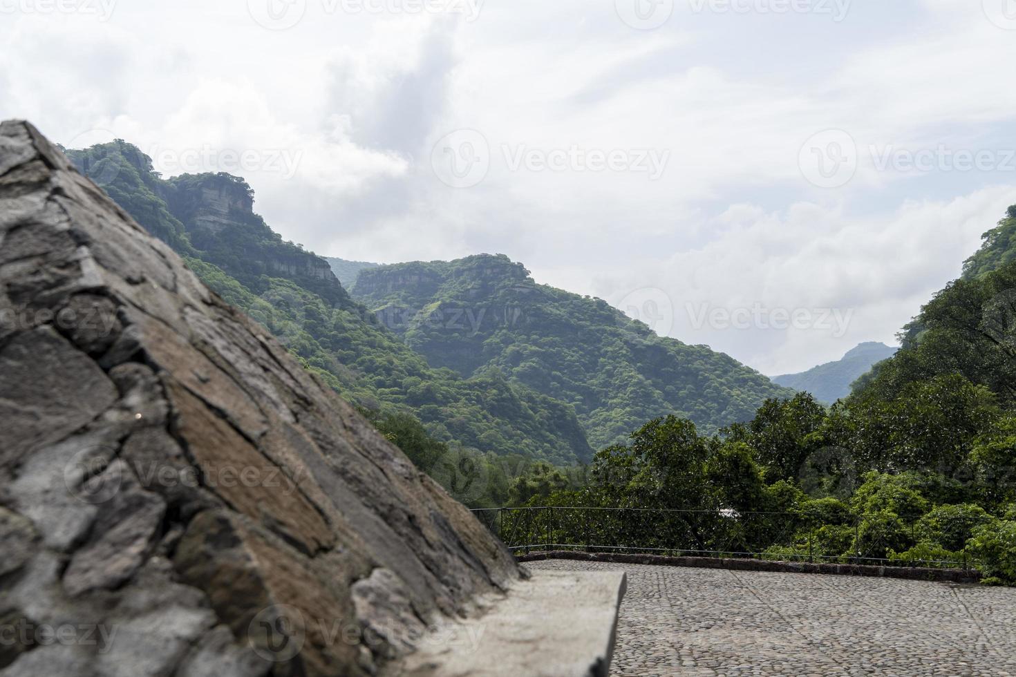 stone pyramid and stone floor in the background vegetation mountains, clouds and sky, barranca de huentitan, guadalajara photo
