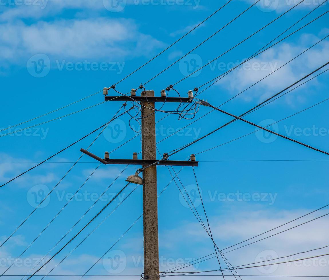 poste eléctrico líneas eléctricas cables eléctricos salientes contra el cielo azul de nubes. foto