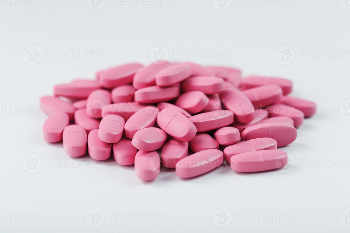 pastillas de vitamina rosa para mujeres de fondo blanco. foto