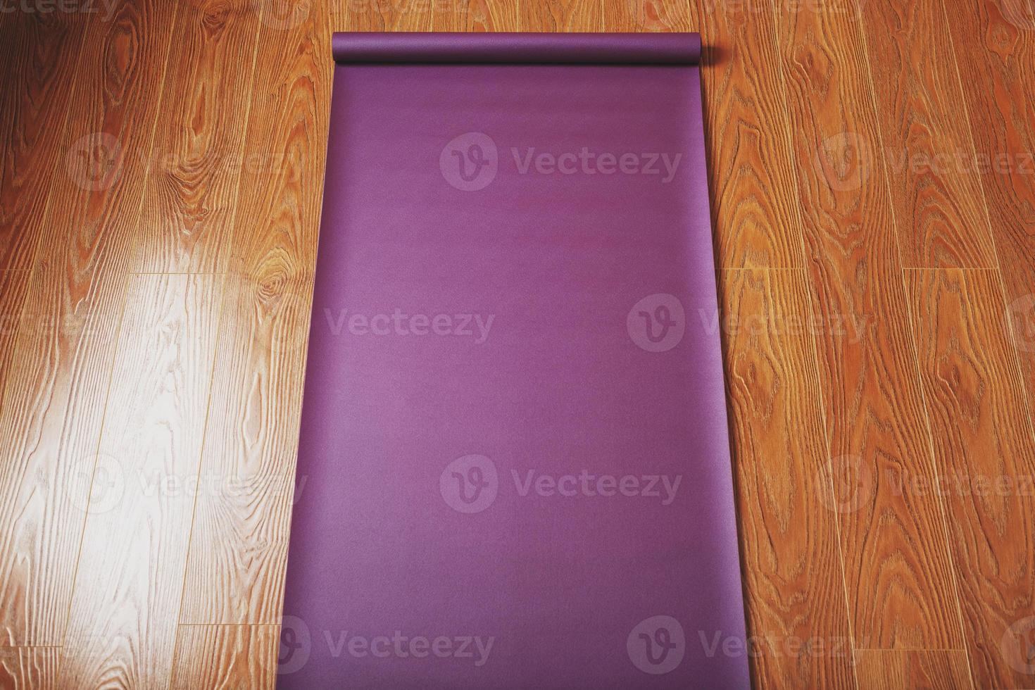Purple yoga and fitness mat on wooden floor photo
