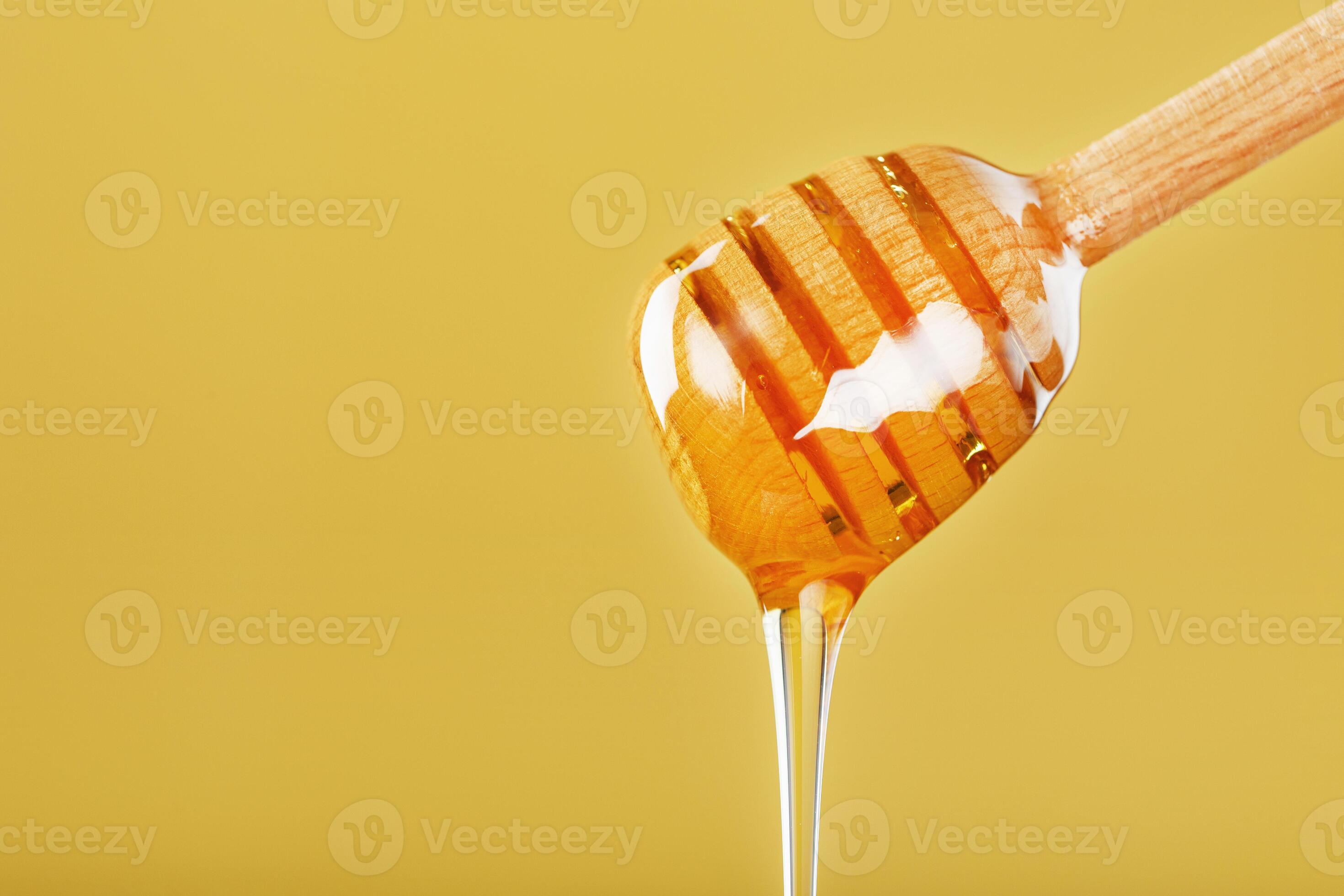 Natural Honey flows down from a honey bucket on a yellow background