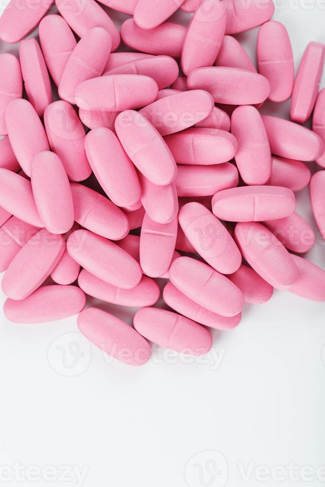 pastillas de vitamina rosa para mujeres de fondo blanco. foto