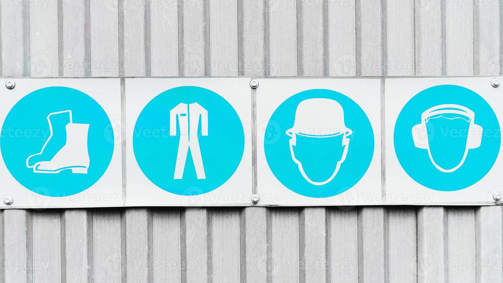 Posters with signs of safety of personal protective equipment in production in a row. photo