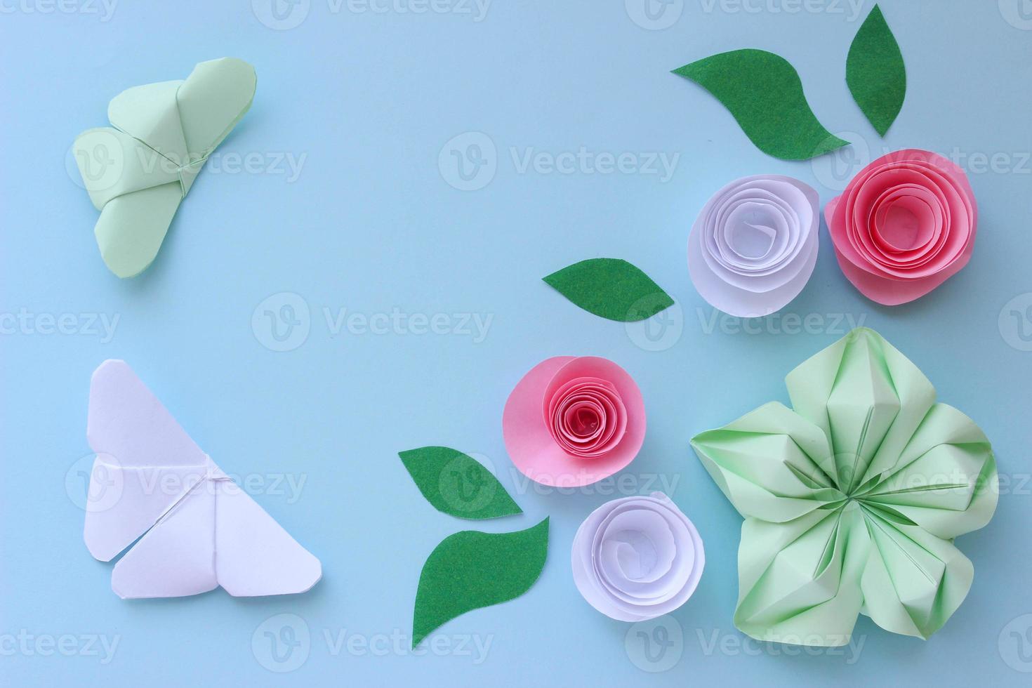 Origami paper background with two butterflies, flowers and leaves. With place for text. Origami composition. Paper craft photo