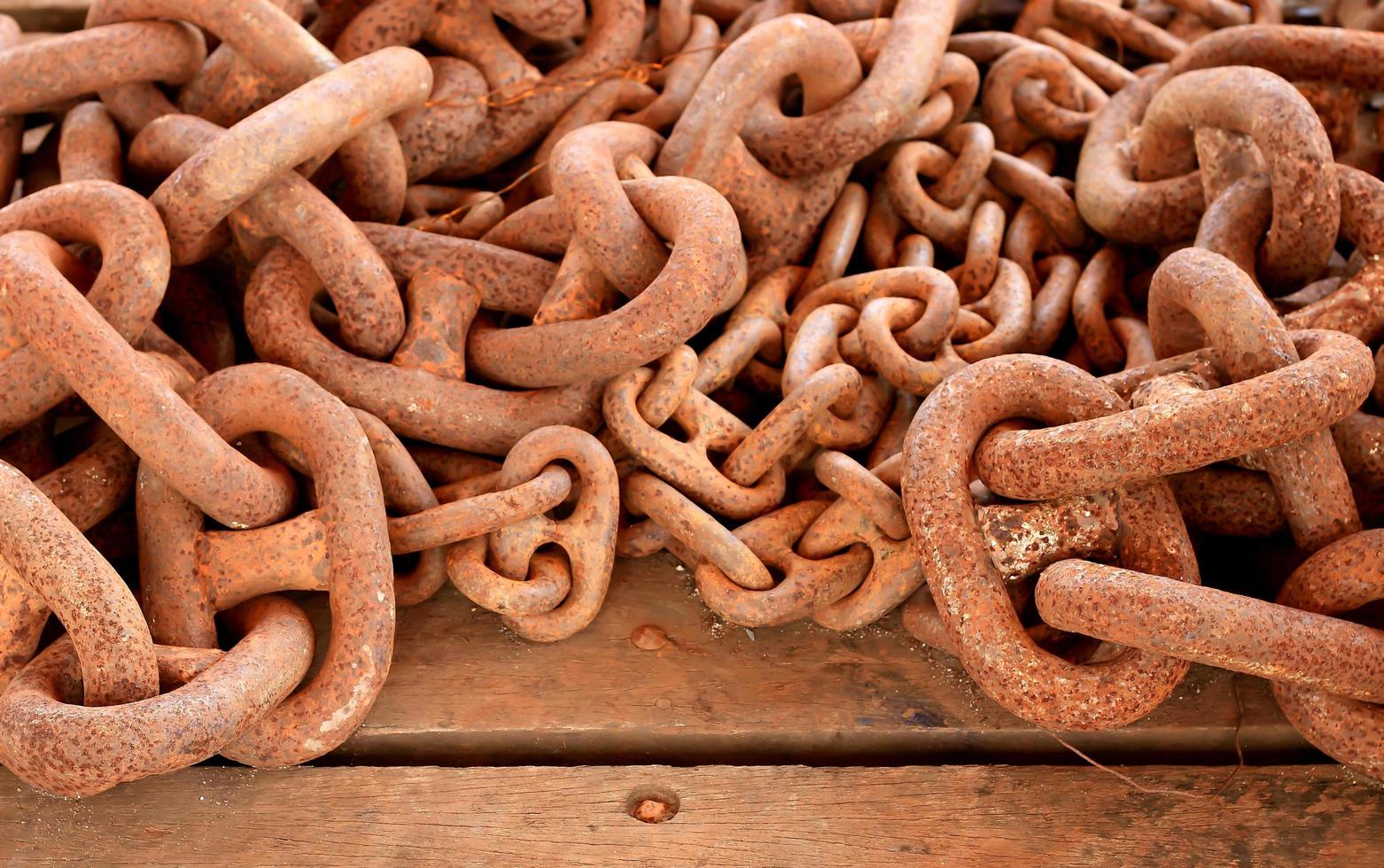 Old rusty chain on wooden background photo