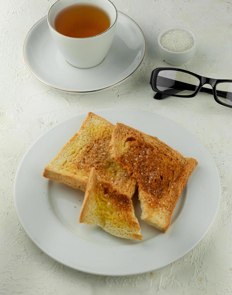 toast with butter and sugar served with a cup of tea photo