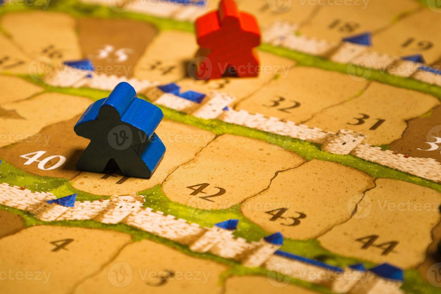 Board games meeples standing on score track close-up photo